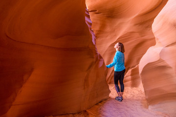 Young woman in Antelope Canyon in Arizona. Tourist in Antelope Canyon. Adventure and hiking concept. - obrazy, fototapety, plakaty