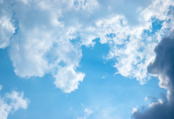 Blue sky and white clouds blue sky on a bright day with white clouds coming in floating come to cover sun causes a white beam causing beauty in the sky.
