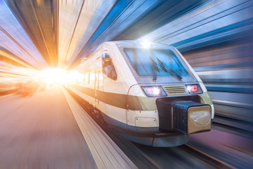 Railroad travel passenger train with motion blur effect, industrial a district of the city