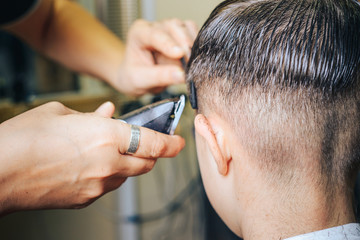 A professional hairdresser makes the design of the head, shave your head electric razor. Beauty...