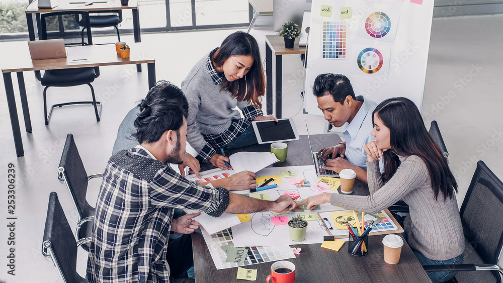 Wall mural female creative director team leader brainstorm branding project with designer team at meeting table