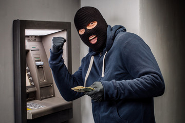 Thief. Hacker stealing money from ATM machine. Phishing, ATM skimming