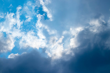 Blue sky and white clouds blue sky on a bright day with white clouds coming in floating come to cover sun causes a white beam causing beauty in the sky.