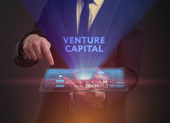 The concept of business, technology, the Internet and the network. A young entrepreneur working on a virtual screen of the future and sees the inscription: Venture capital