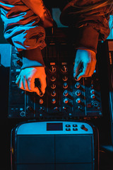 top view of dj woman touching dj mixer in nightclub