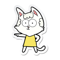 Obraz na płótnie Canvas sticker of a happy cartoon cat in dress pointing