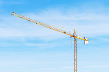 Tower crane with slings against blue sky