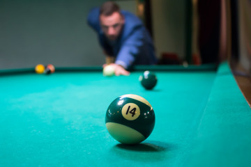 the billiard player aimed at the green ball number 14 and gone make a punch