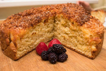 a piece of homemade coconut cake with berries strawberry and blackberry