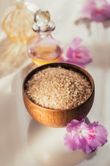 Sea salt, natural handmade soap, natural cosmetic oil and colorful towels with azalea flowers on rustic wooden background