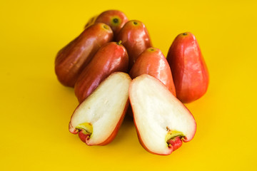 Syzygium Aqueum , Bell fruit or Jambu Air in local Malay language, is a fruit that has a shape like a bell; shot on isolated yellow background.