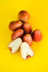 Syzygium Aqueum , Bell fruit or Jambu Air in local Malay language, is a fruit that has a shape like a bell; shot on isolated yellow background.