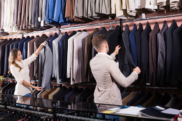 Glad couple examining various suits