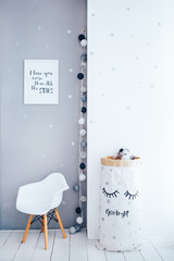 Children's room with a gray wall, interior details. Toy bag and white chair