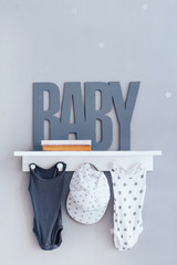 Shelves with hanger in modern baby room. Text baby.