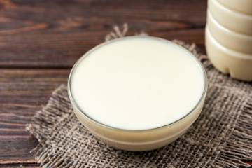 Boiled condensed milk on dark wooden background.