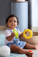 Cute baby girl playing with colourful toys