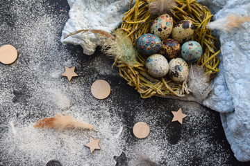 bright Easter background; Easter eggs basket and sprig flowers on blue table background