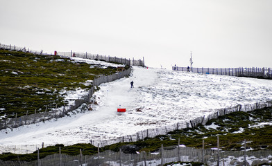 Unrecognizable people practicing skiing in the snow on a ski slope on the mountain on La Covatilla, Bejar (Salamanca)