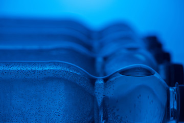 close up of plastic water bottles with bubbles and copy space on blue background