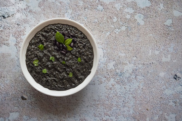 Plate of black soup mashed black beans. Top view.