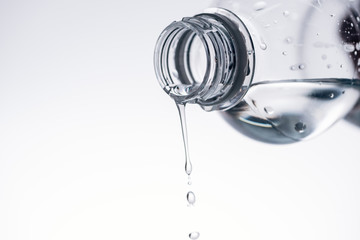 water dripping from plastic bottle isolated on white with copy space