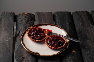 cherry tartlets on dark wooden backdrop, rustic style