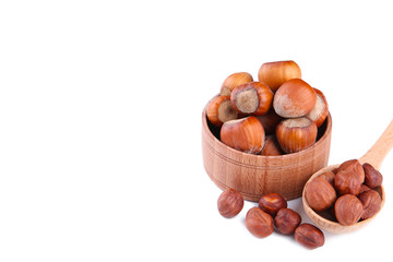 Delicious hazelnut in the wooden bowl and spoon isolated on white background