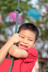 Asean boy at the nodes the rope and smiling happily.