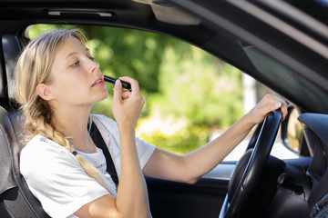 a woman is doing makeup while in the car