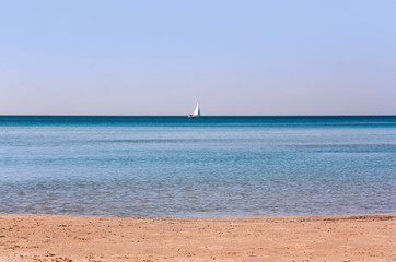 Fototapeta na wymiar morning seascape with a sailboat on the horizon