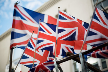 London, Great Britain - May 12, 2012: Union Jack British flags waving in the wind with a white...