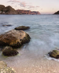 Fototapeta na wymiar Black Sea, photo on a long exposure at sunset. Waves and stones.
