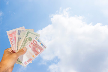 Many currency bangknote in hand with blue sky background