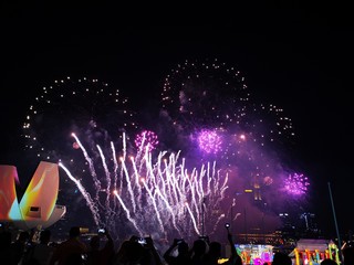 The crowd celebrates the Chinese New Year in Singapore. Silhouettes of people watching a fireworks display. Stock photo.