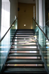 Modern glass staircase leading upward with handrail