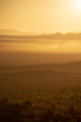 Fototapeta na wymiar The sun rising over the mountains of the Arizona desert with natural warm hues.
