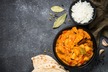 Chicken tikka masala with rice on black top view.
