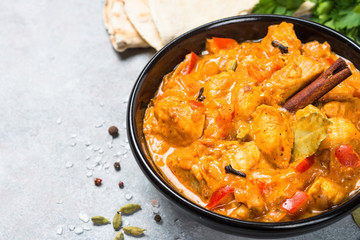 Chicken tikka masala with rice on black top view.