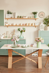 bright kitchen in the style of Provence, on the table dishes and a bouquet of flowers in a vase