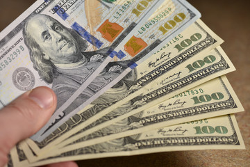 Hand holding hundred dollar bills