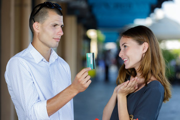 rich man is giving woman debit card