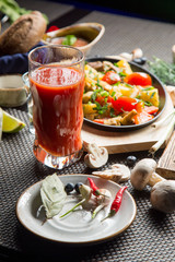 Tasty roast of vegetables and meat with tomato juice. Tomato juice in a glass.