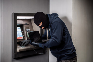Hacker stealing password and identity on atm machine. Computer crime concept.