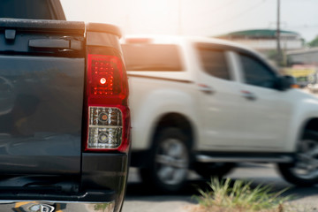 Pick up gray color stop on the road with faster of white car on front.