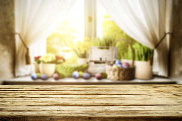 Wooden table of free space for your decoration. Spring window background. Easter eggs and flowers on window sill. 