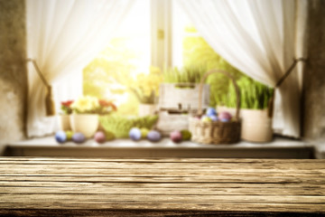 Wooden table of free space for your decoration. Spring window background. Easter eggs and flowers on window sill. 