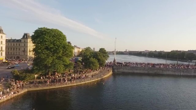 Aerial shot of Copenhagen lake with people chilling relaxing on the grass and partying crowd on Dronning Louises Bro at Distortion Music Festival