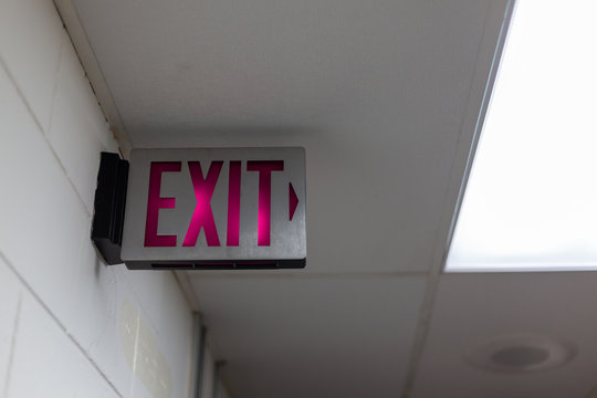 red emergency exit sign in the dark room. illuminated office exit sign.