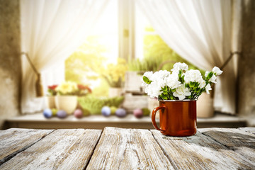 Wooden table of free space for your decoration. Spring window background. Easter eggs and flowers on window sill. 